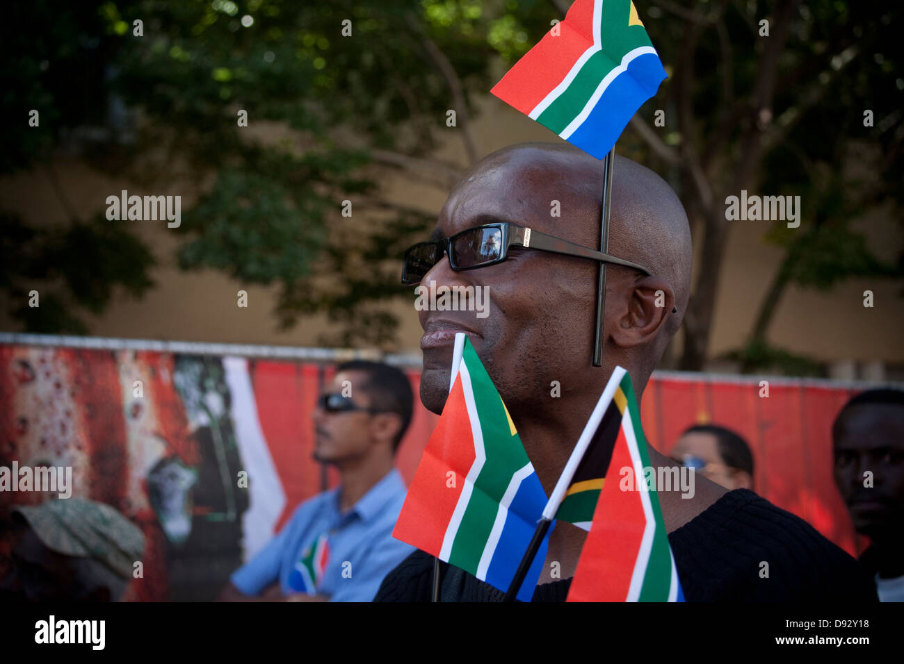 Un fanático del fútbol sudafricano llevando banderas de Sudáfrica siente la atmósfera durante el sorteo final de la Copa Mundial de la FIFA en fiestas Foto de stock