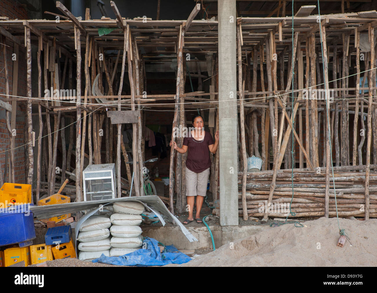 La mujer en el frente de su casa en construcción, Thakhek, Laos Foto de stock