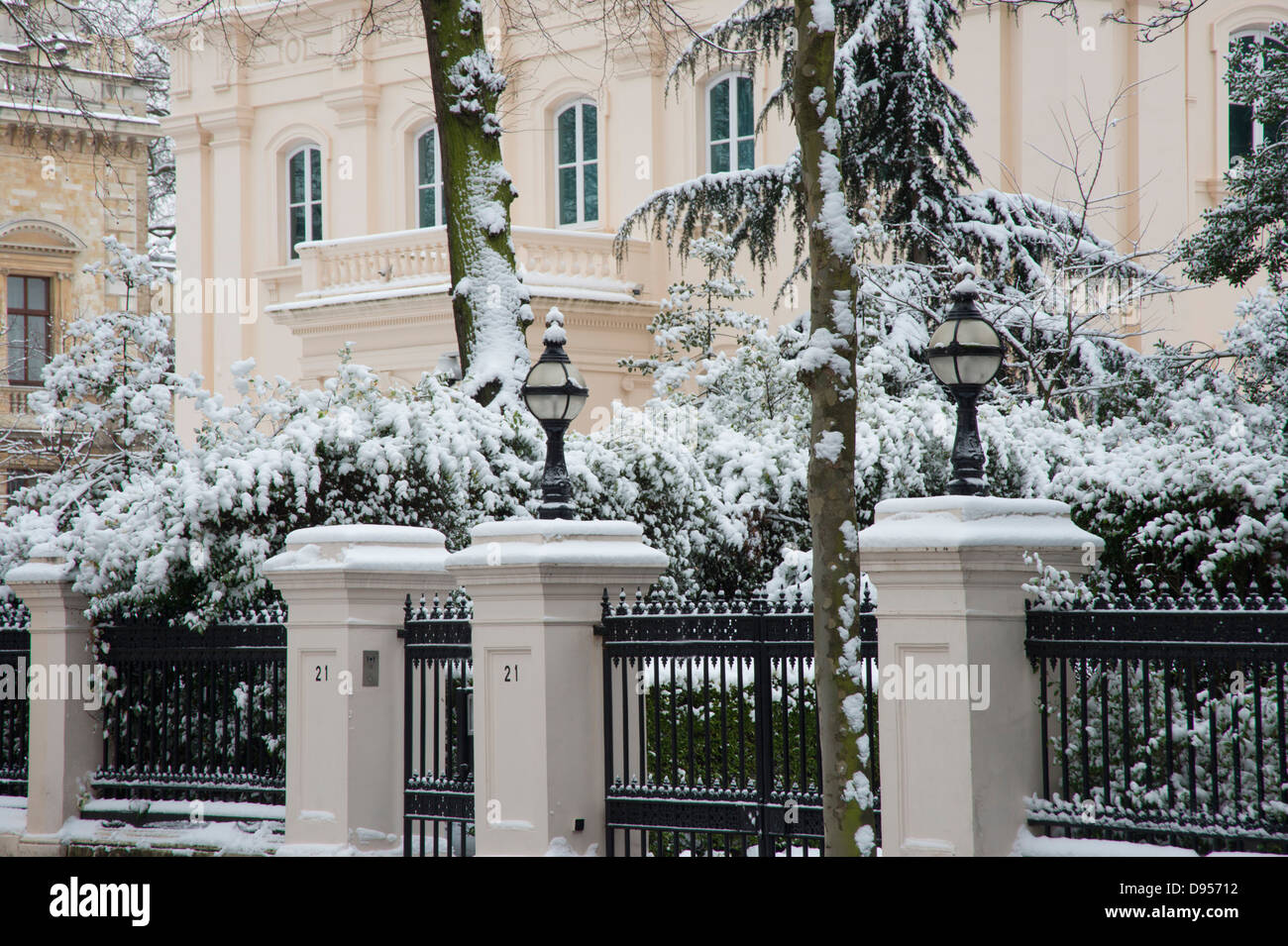 Nieve en árboles delante de mansiones en Palacio Gate, London, UK Foto de stock