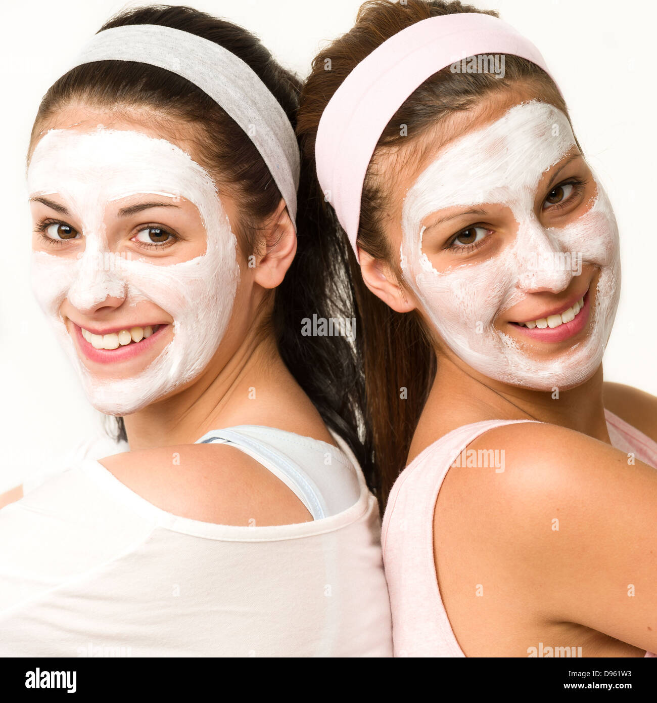 Las niñas de raza blanca feliz con máscara facial blanca Foto de stock