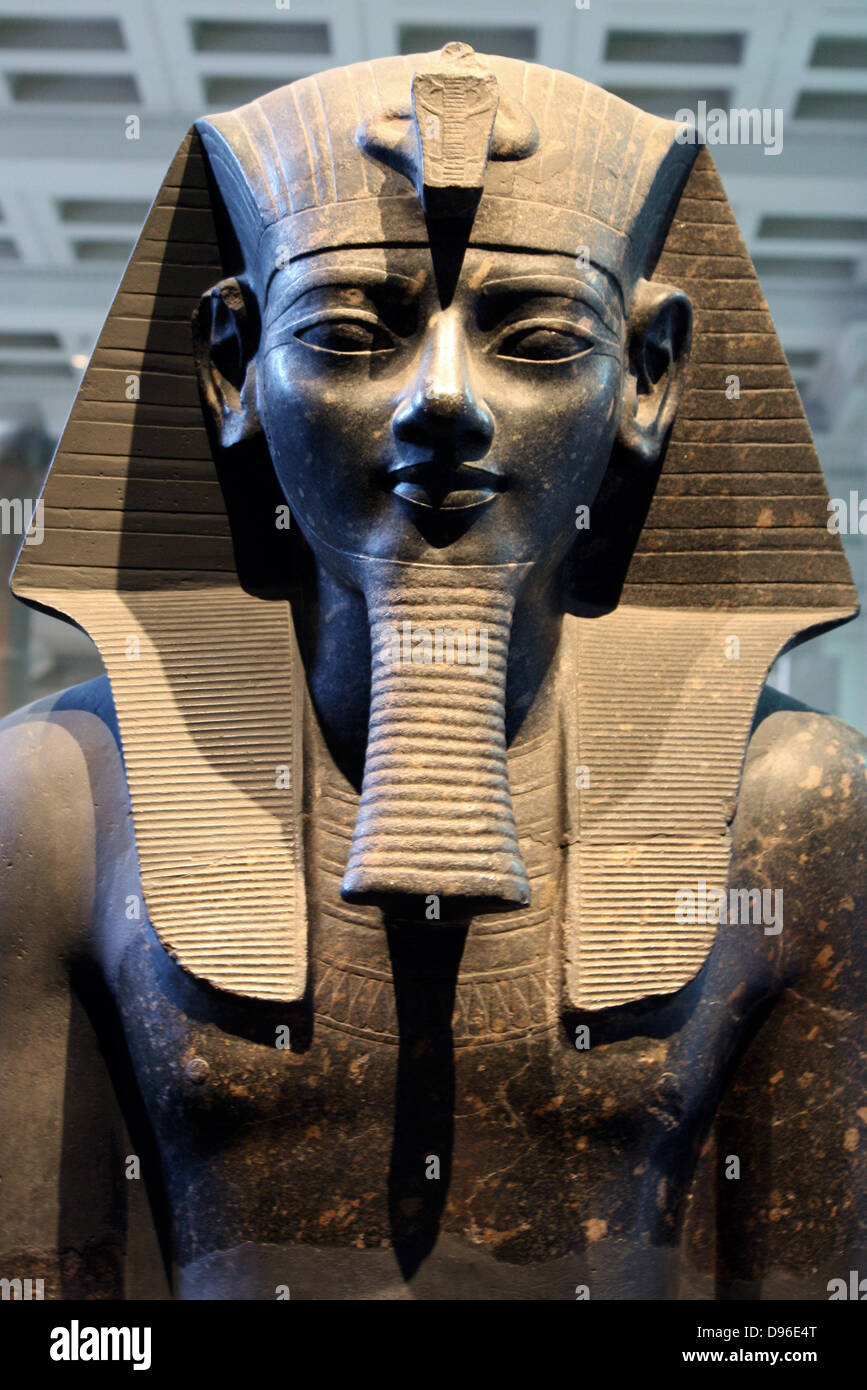 Estatua del rey Amenhotep III. Xviii dinastía, alrededor de 1400 A.C. el rey de Tebas está representado en el clásico pose y vestimenta. Sentado en un trono con ambas manos planas en las rodillas, ella lleva un nemes-headcloth, falsa barba y falda corta, que equipado con una ceremonia de rabo de toro, que se muestra entre las piernas. El rey de los nombres están inscritos en la parte frontal y posterior del trono y de la correa de la falda. Foto de stock