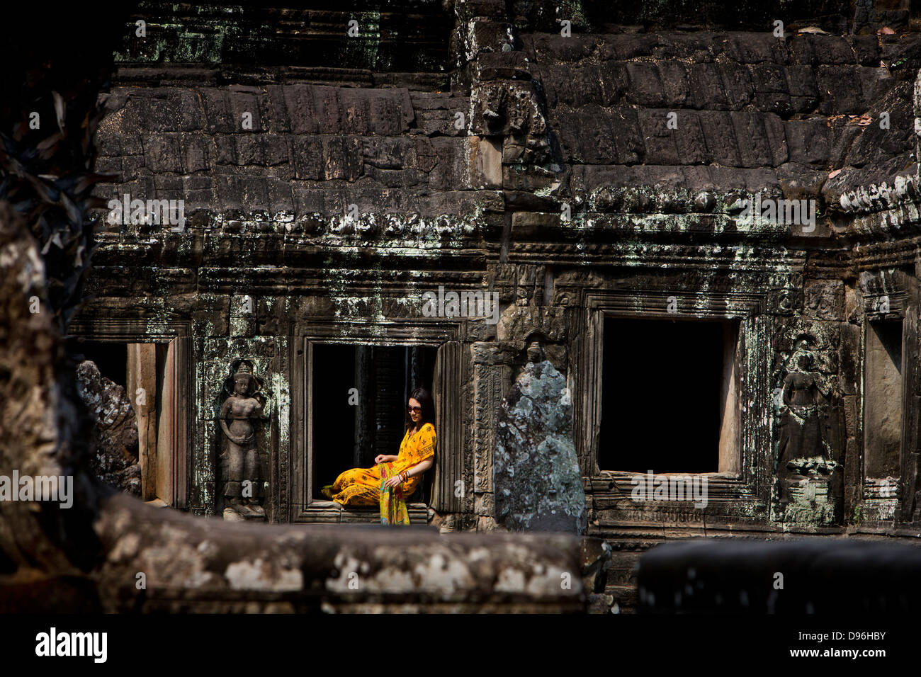Mujer China ropa de modelado en las ruinas del templo, Ta Prohm, Ankor Wat Camboya Foto de stock