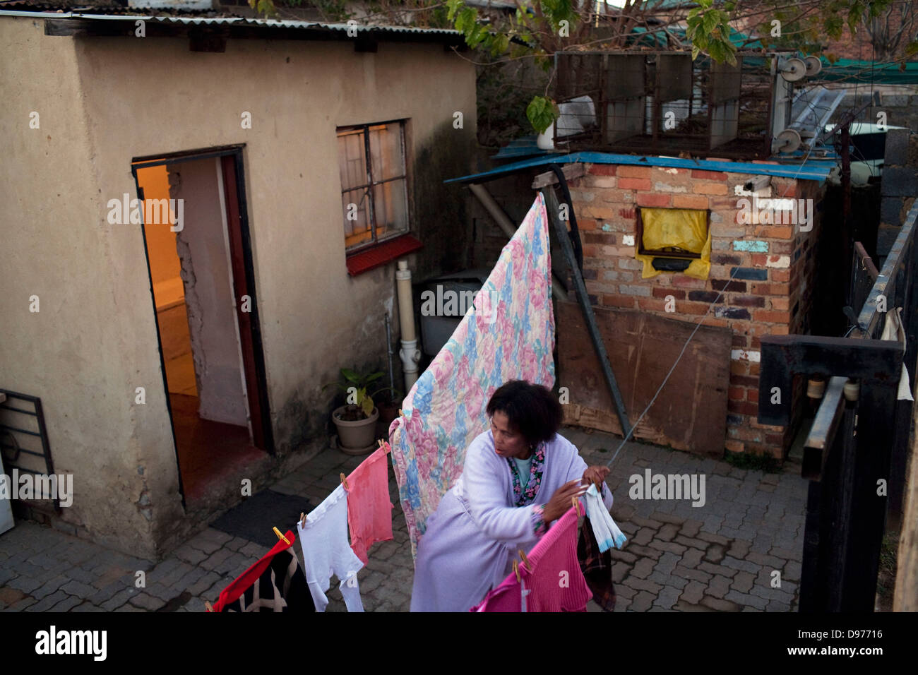 Sesenta y nueve años de edad, Alina Thonjeni cuelga fuera lavado en back yard guesthouse.(Credit: Nikki Rixon/22diez/Africa Media Foto de stock
