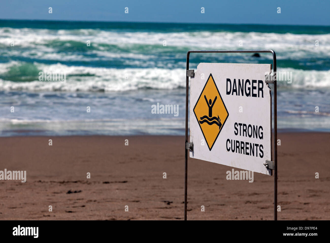 Peligro - corrientes fuertes. Cartel visto en la playa en Nueva Zelanda. Foto de stock