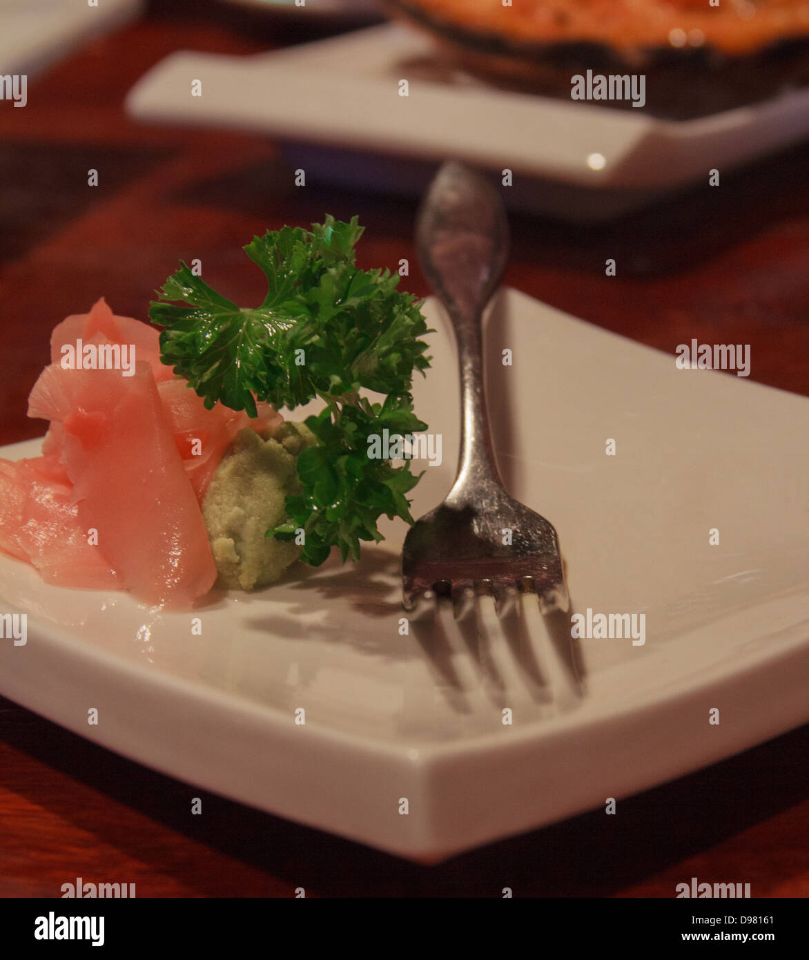 Plato de sushi con jengibre, wasabi, perejil y una horquilla Foto de stock