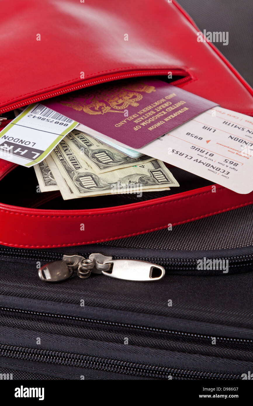 Maleta con una bolsa roja con un pasaporte con boletos de avión, la moneda  y la etiqueta de equipaje Fotografía de stock - Alamy