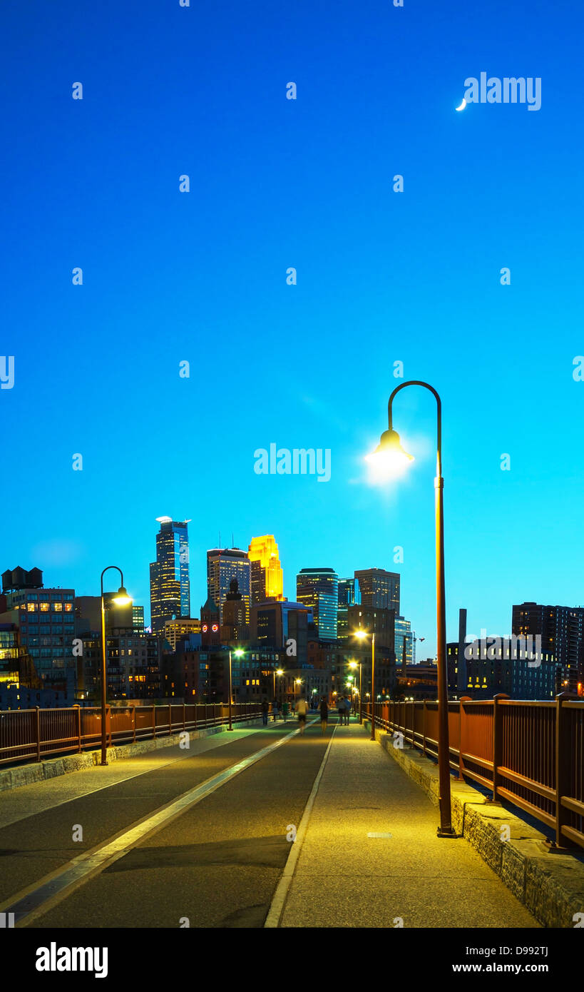 El centro de Minneapolis, Minnesota, en la noche del tiempo, como se aprecia desde el famoso puente de arco de piedra Foto de stock