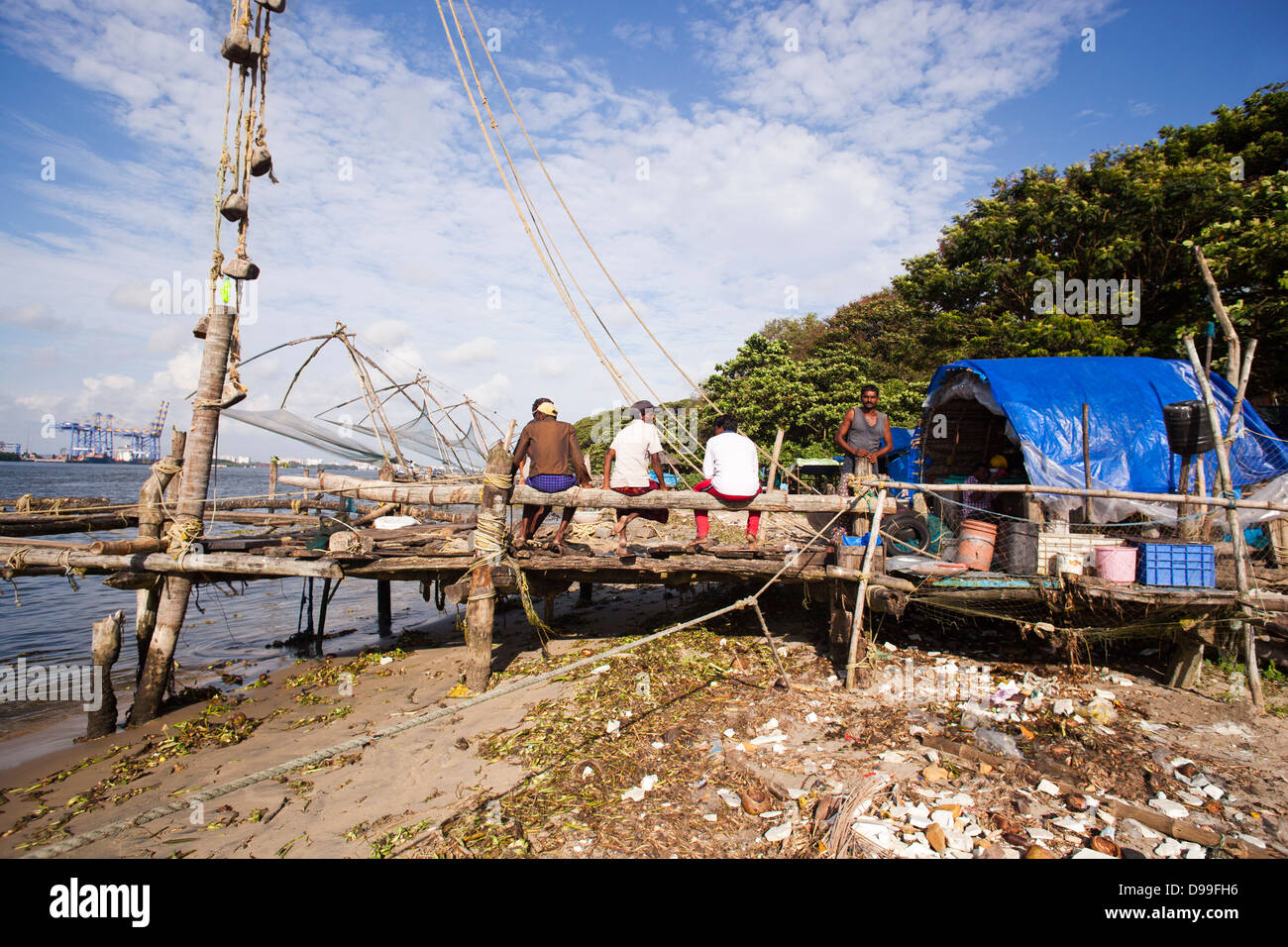 Los pescadores con redes de pesca chino en un puerto, Cochin, Kerala, India Foto de stock