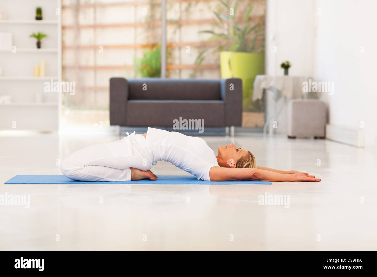 Señora madura hacer yoga en casa Foto de stock