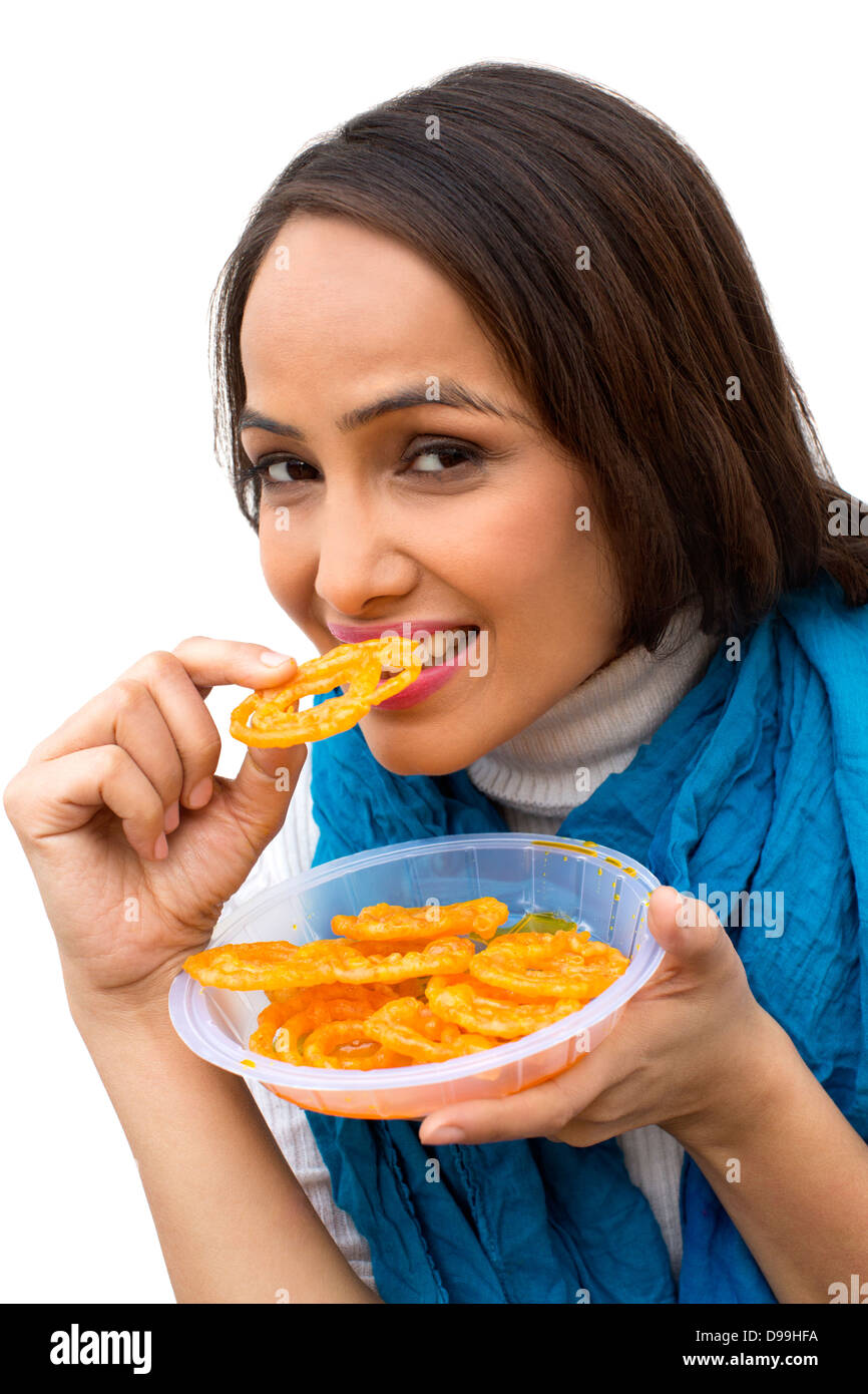 Retrato de una mujer comiendo jalebi Foto de stock