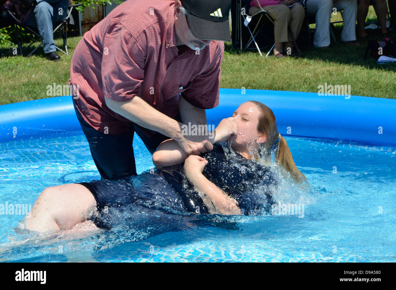 Una joven mujer obtiene bautizados en una ceremonia al aire libre Foto de stock