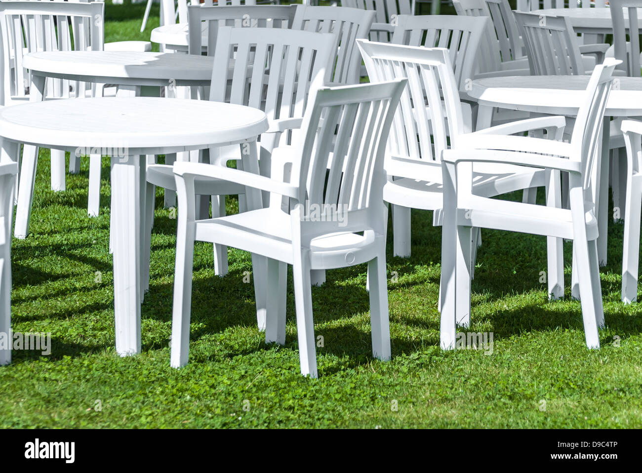 Jardín con mesas y sillas de plástico blancas sobre el césped Fotografía de  stock - Alamy
