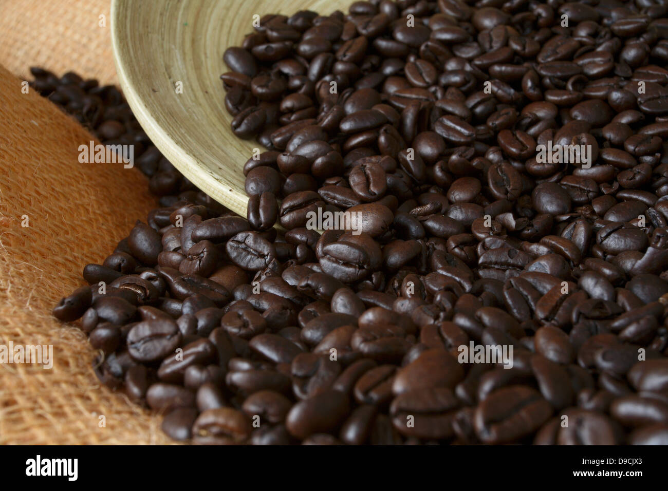 Los granos de café con recipiente de madera Foto de stock