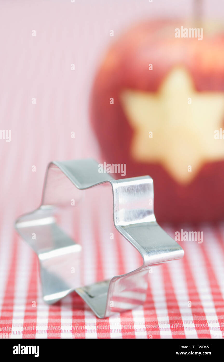 Forma de estrella de navidad cookie cutter delante de apple curvo Foto de stock