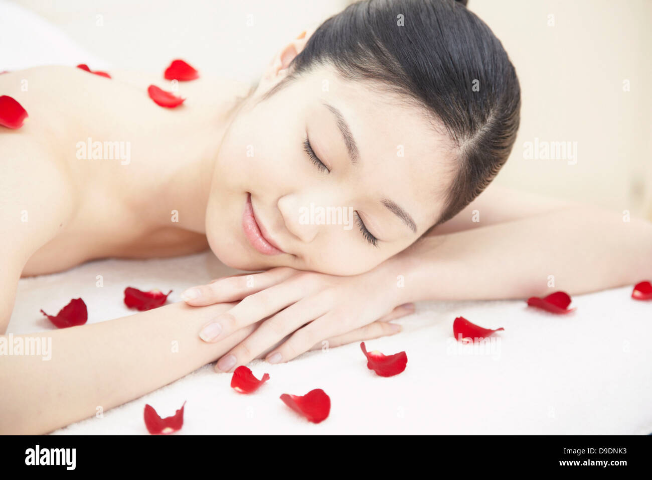 Mujer cubierto de pétalos de rosa Foto de stock