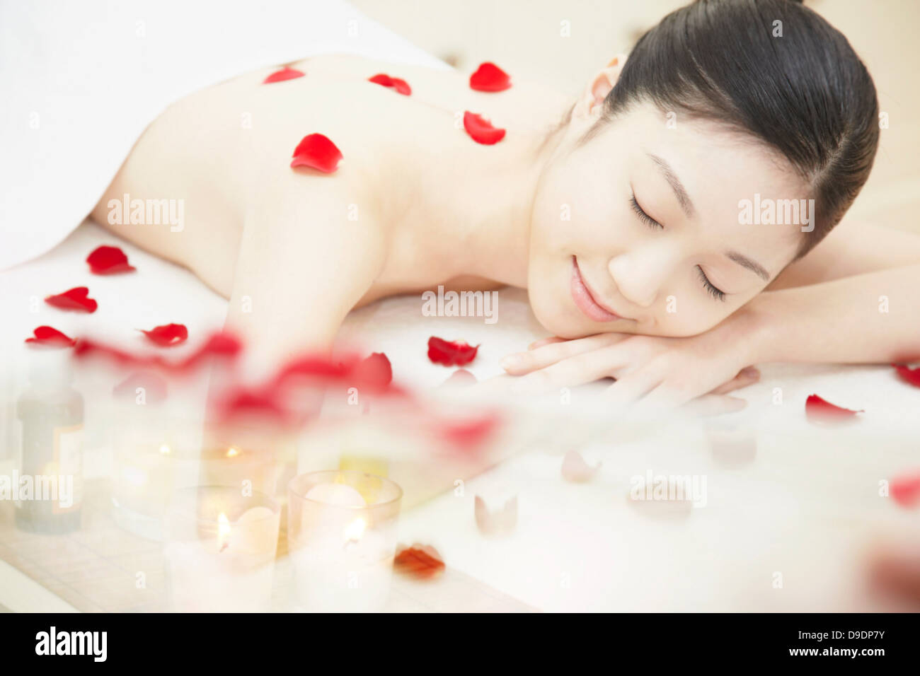 Mujer cubierto de pétalos de rosa Foto de stock