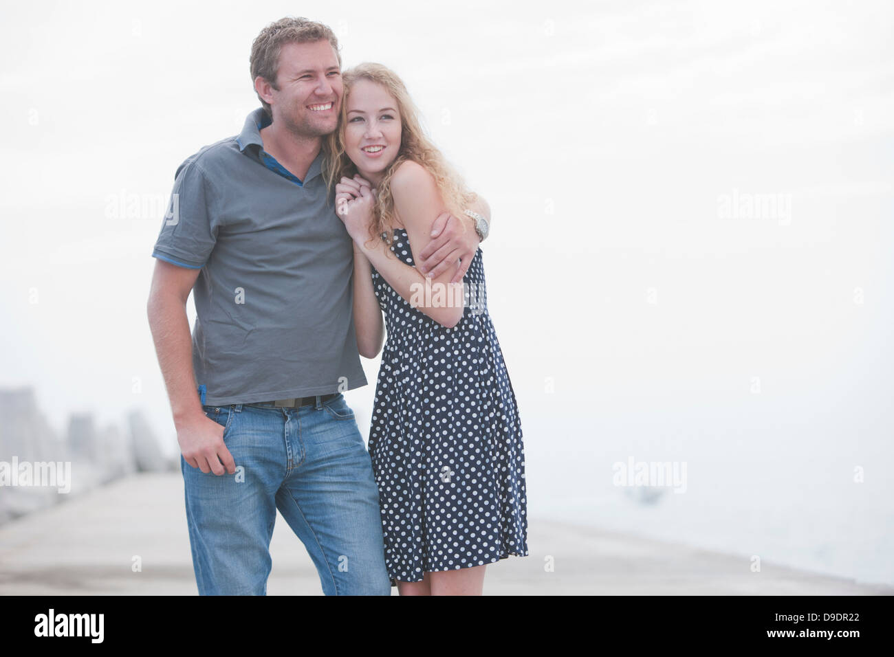 Pareja joven de pie juntos en el muelle Foto de stock
