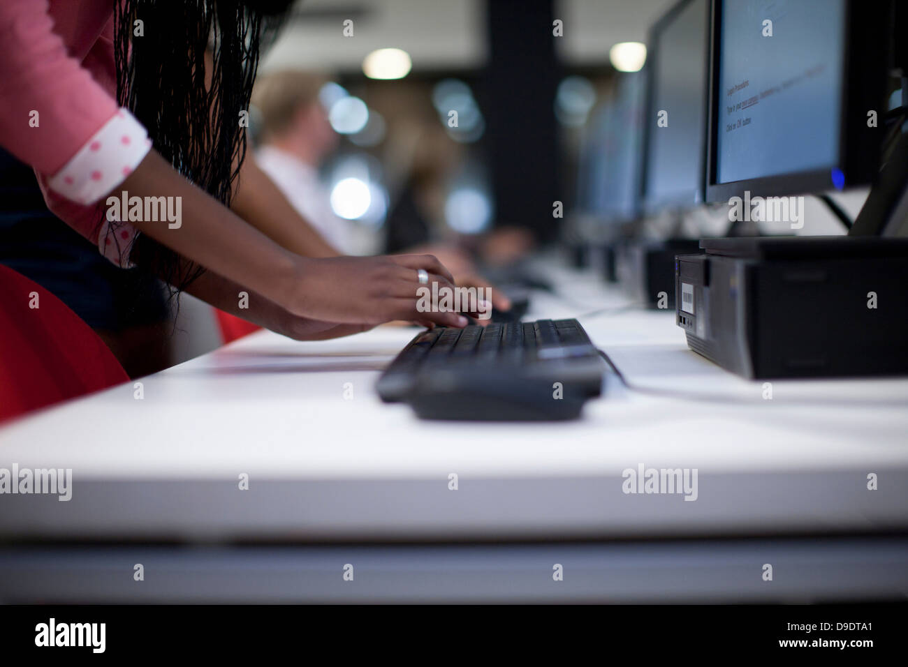 Estudiante femenina mediante teclado de computadora en clase Foto de stock