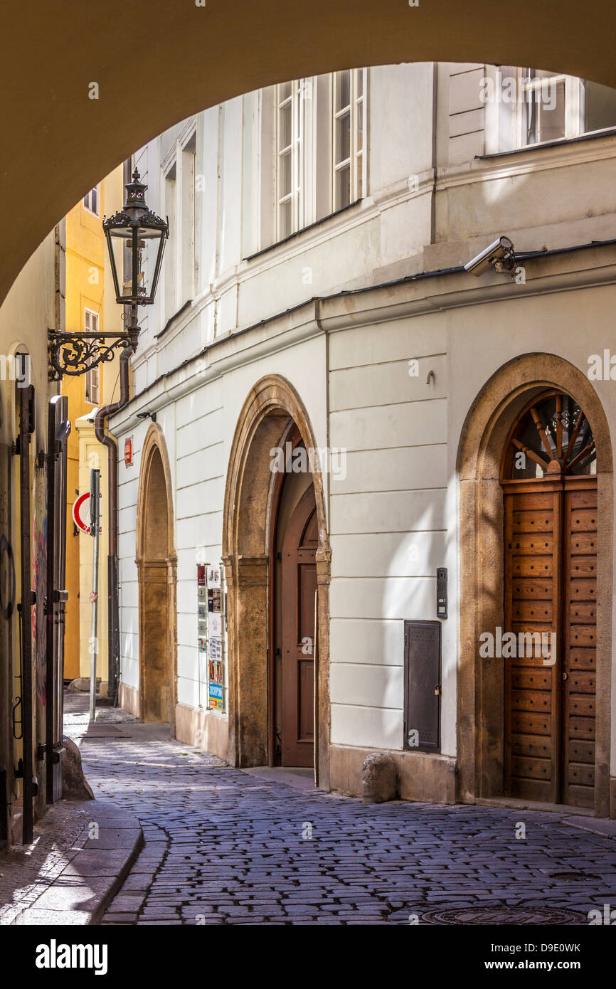 Vista a través de un arco con una pequeña callejuela empedrada en el distrito de la Ciudad Vieja de Praga, Praga, República Checa; Česká Republika. Foto de stock