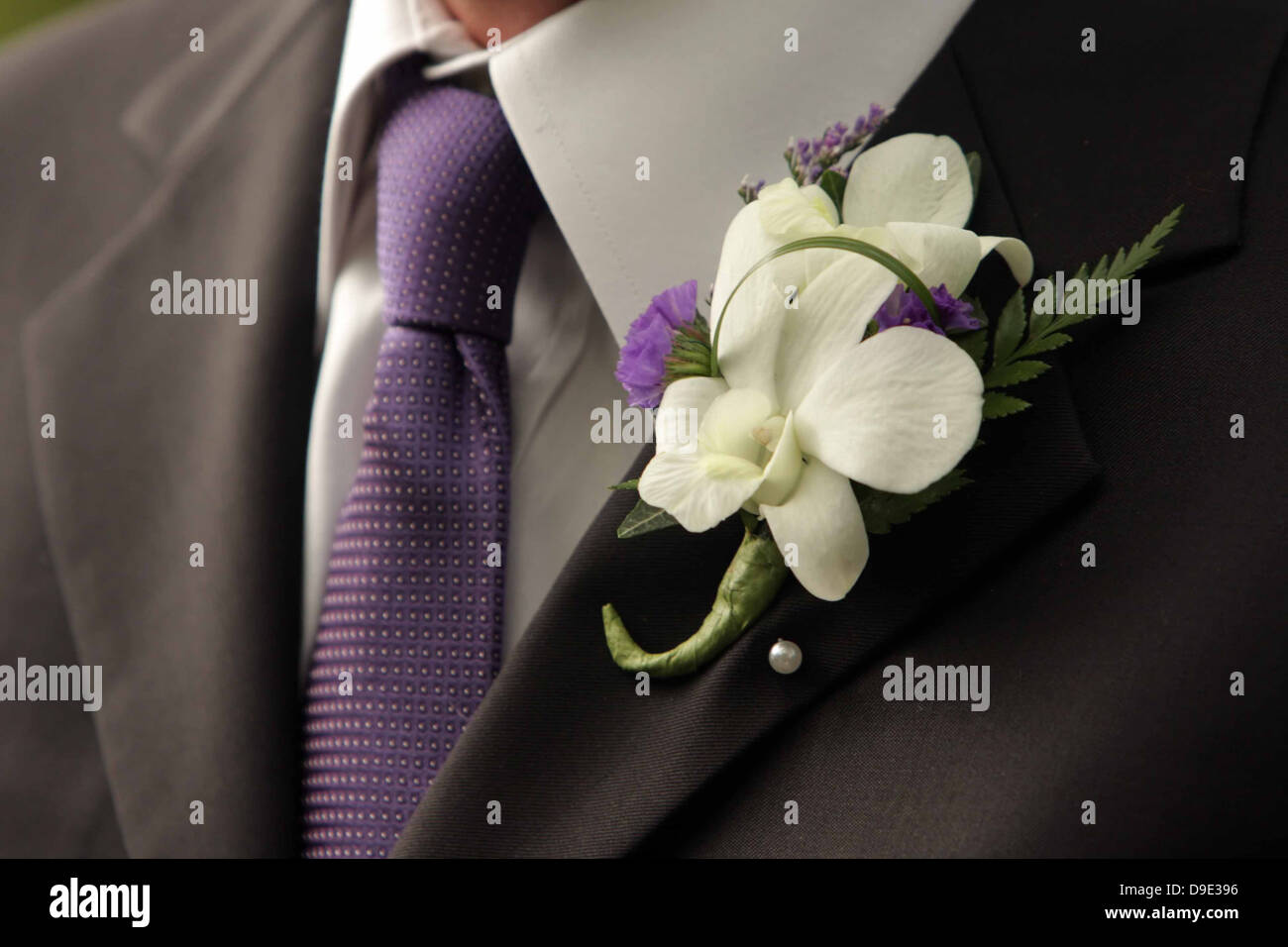 MENS hombre traje negro, camisa blanca y corbata púrpura verde violeta  Blanca Flor en el ojal Fotografía de stock - Alamy