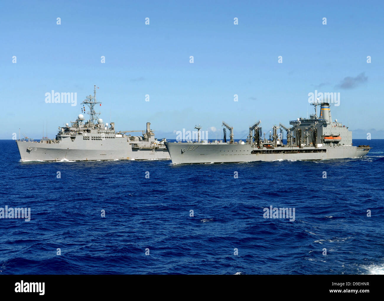 USS Denver y USNS Pecos realizar una reposición en el mar. Foto de stock