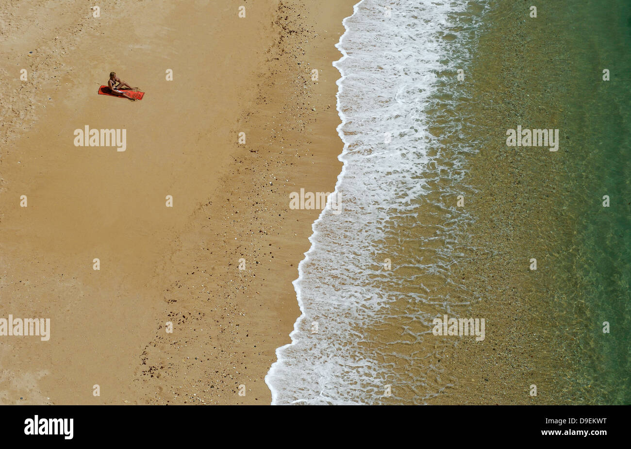 El solitario adorador solar en una playa de Algarve, Portugal. Foto de stock