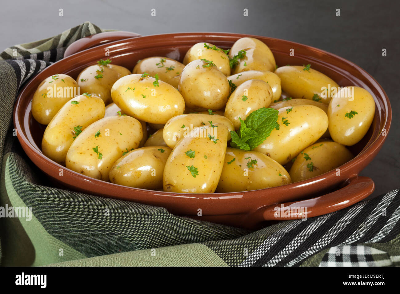 Las nuevas papas cocidos al vapor - nuevas patatas en sus pieles con aceite de oliva virgen extra, Perejil y Menta. Foto de stock