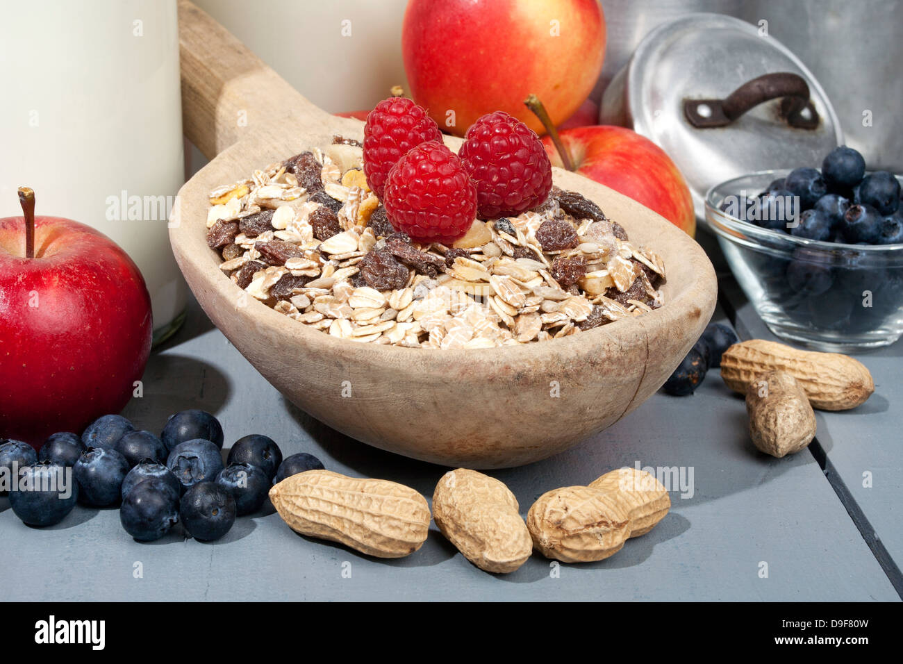Paleta de madera con cereales con frutas y leche, cuchara de madera con cereales con fruta y leche Foto de stock