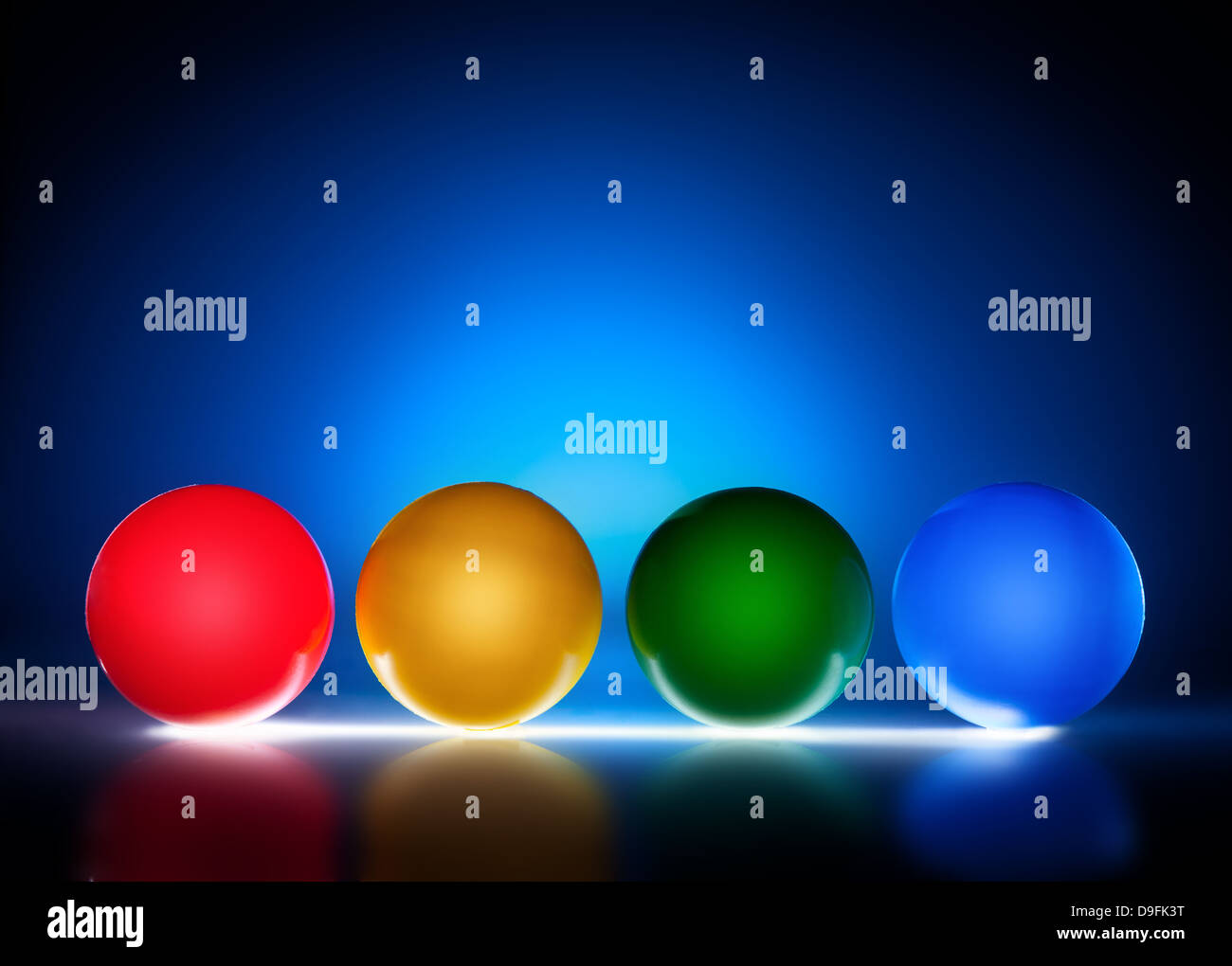 Bolas de plástico color iluminada, la luz de fondo azul Foto de stock