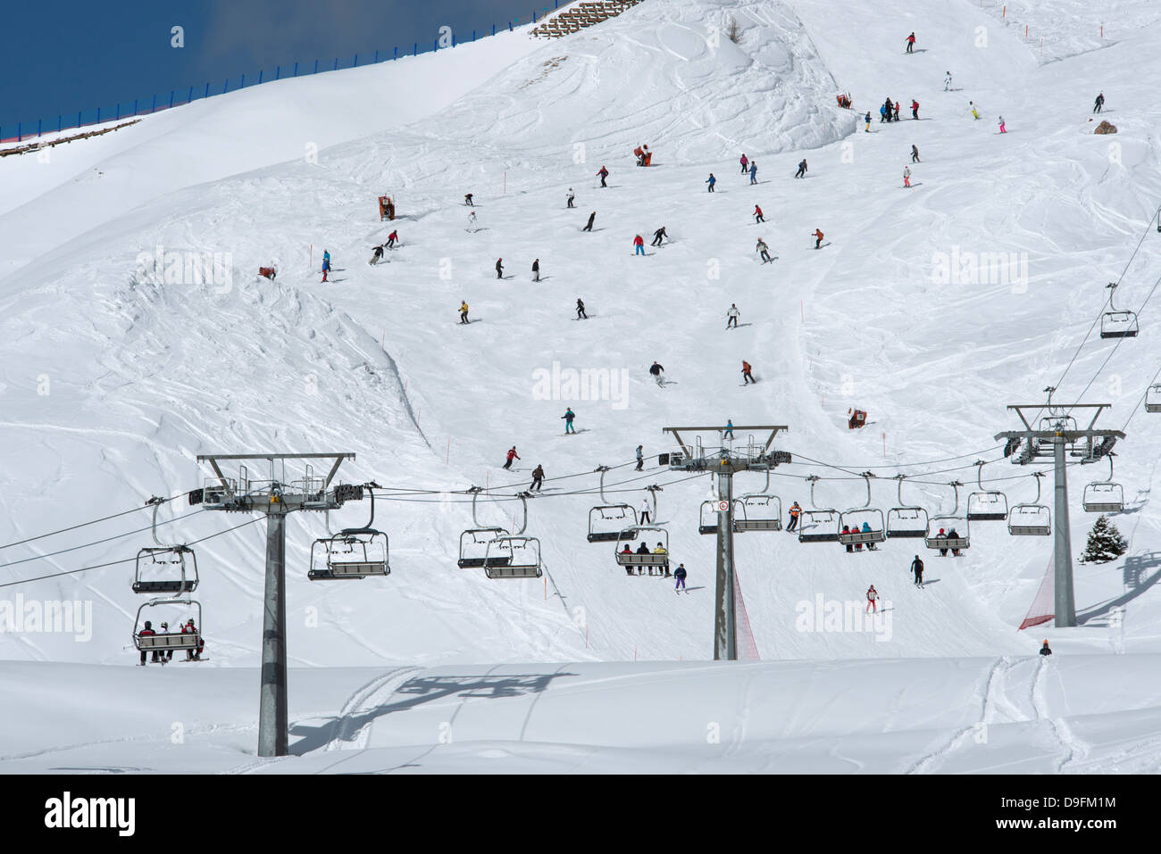 Un telesilla y esquiadores en pista en Passo Sella en los Dolomitas, Tirol del Sur, Italia Foto de stock