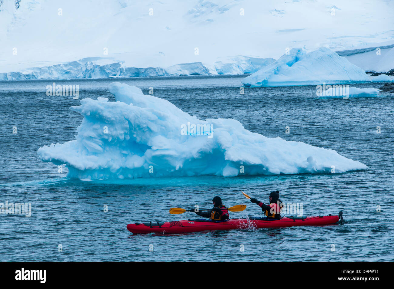 Los palistas remando a través del agua, cerca de la estación de investigación de Puerto Lockroy, La Antártica, regiones polares Foto de stock