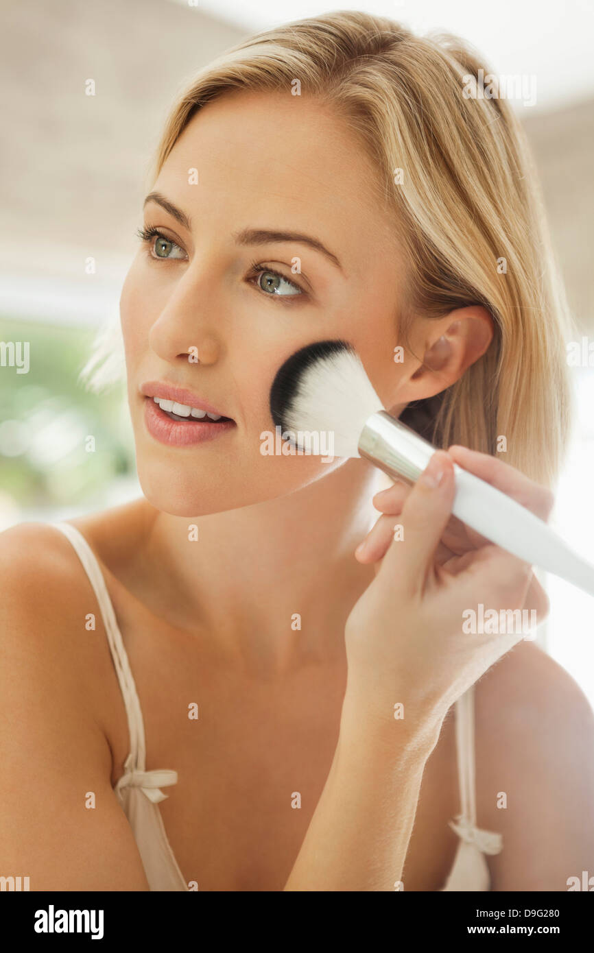 Mujer aplicar el maquillaje con una brocha. Foto de stock