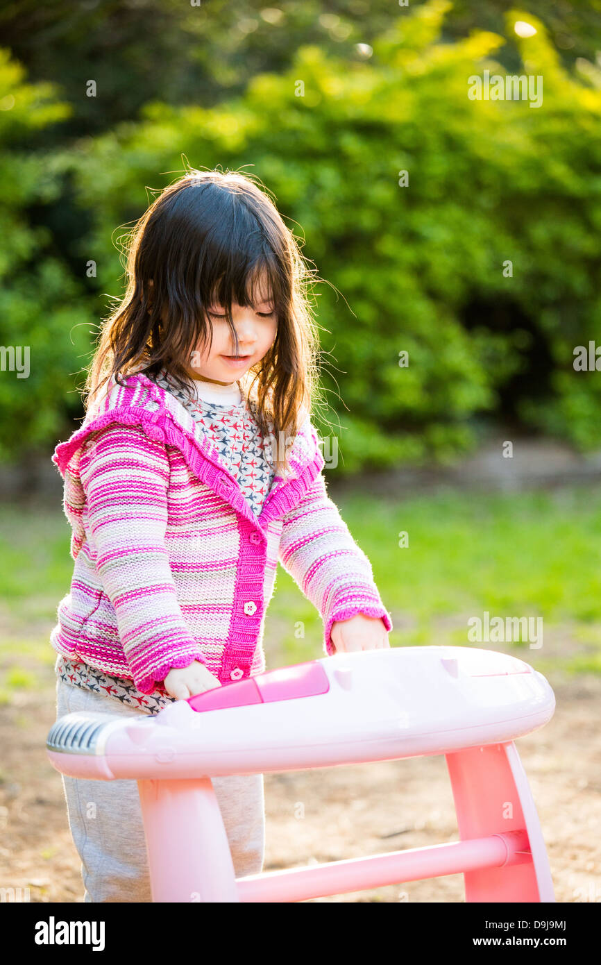 Niña de 3 años de edad tocando el piano de juguete en estacionamiento  Fotografía de stock - Alamy