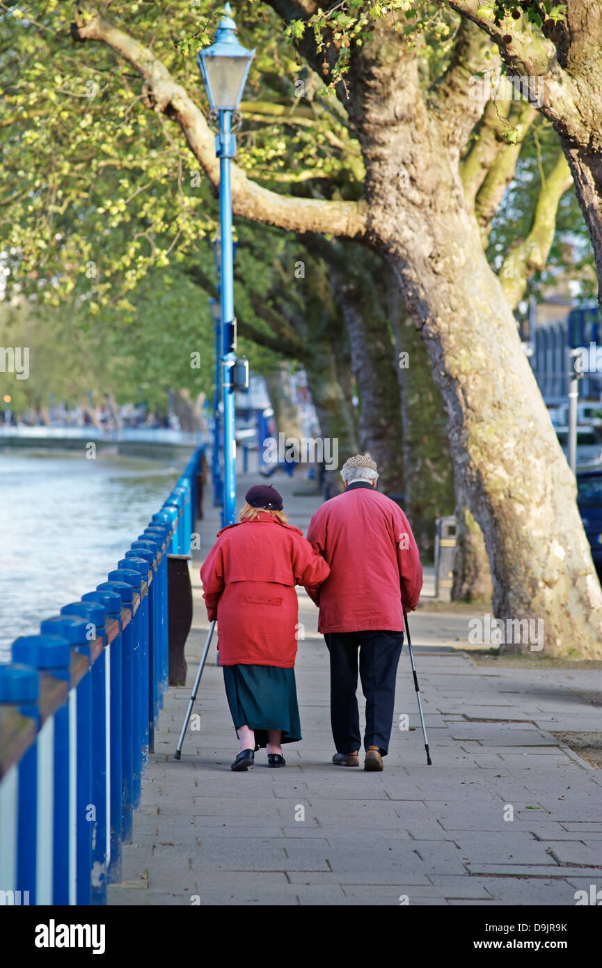 Pareja de ancianos paseando a lo largo del Thames embankment en Putney London SW15 Foto de stock
