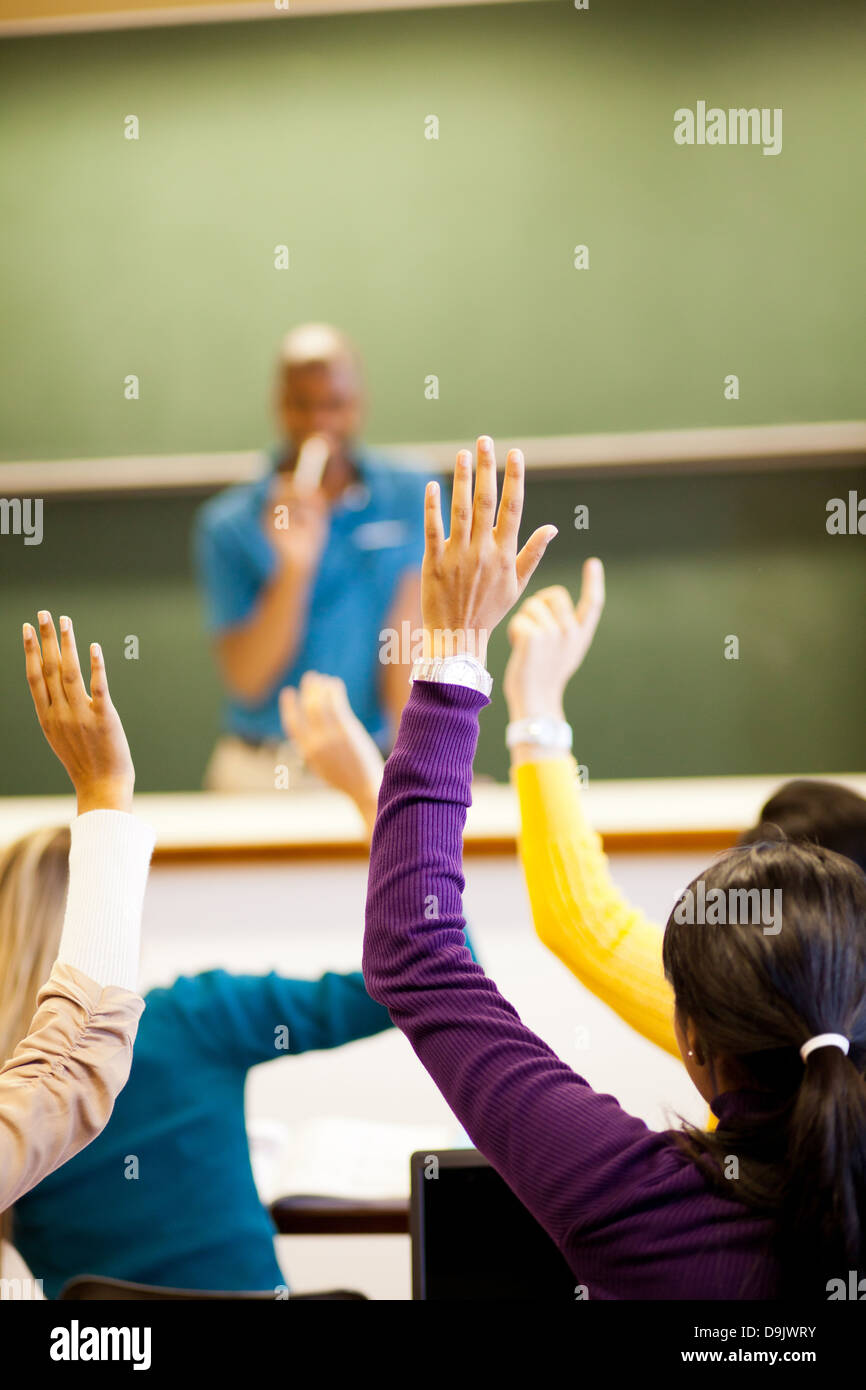Grupo de estudiantes brazos arriba en el aula Foto de stock