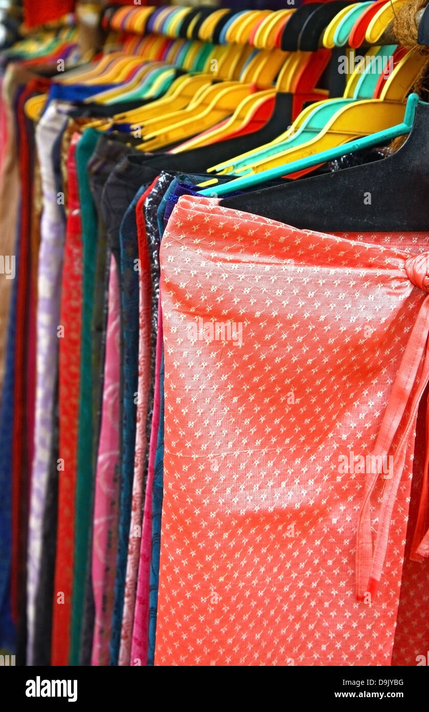 Pantalones de color en la línea en el gancho en la tienda Foto de stock