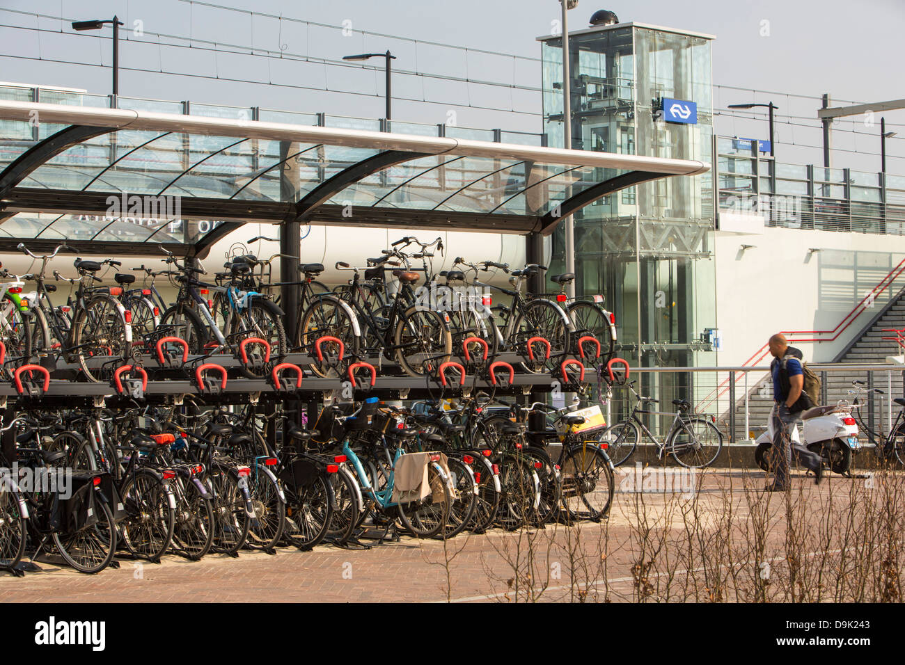 En la estación de tren de Almere, Holanda, con el parque y el paseo de coches y motos. Foto de stock