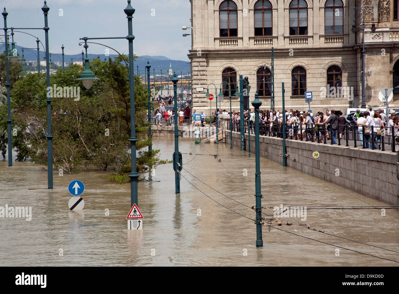 Espectadores y turistas mirando la calle inundada y el tranvía en la ráfaga de los bancos del río Danubio, Budapest, Hungría Foto de stock