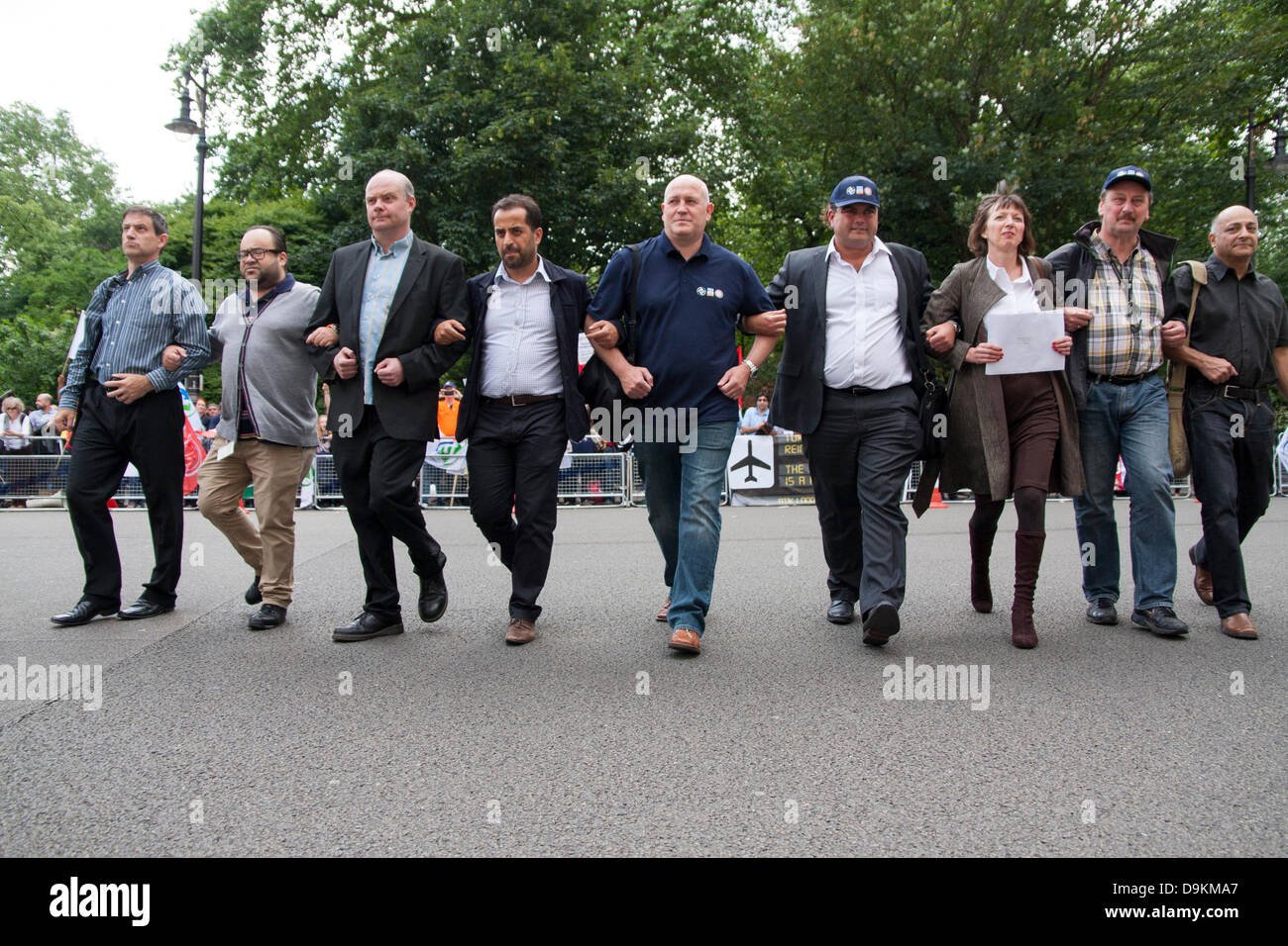 Londres, Reino Unido. El 21 de junio de 2013. Las armas vinculadas, una delegación de la protesta frente a la embajada de Turquía cruza la carretera para entregar un mensaje al embajador británico como turcos y TUC activistas sindicales se manifiestan contra despidos masivos de sindicalistas turco y en solidaridad con el pueblo turco sufre una ofensiva del gobierno tras los disturbios. Crédito: Paul Davey/Alamy Live News Foto de stock