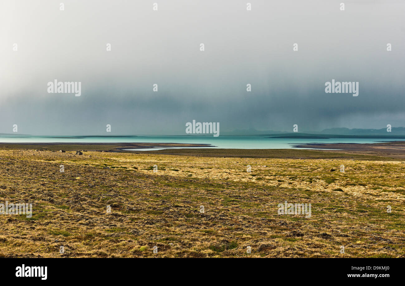 Campo y lago en el paisaje árido, Carretera 35, Blondulon, Islandia Foto de stock