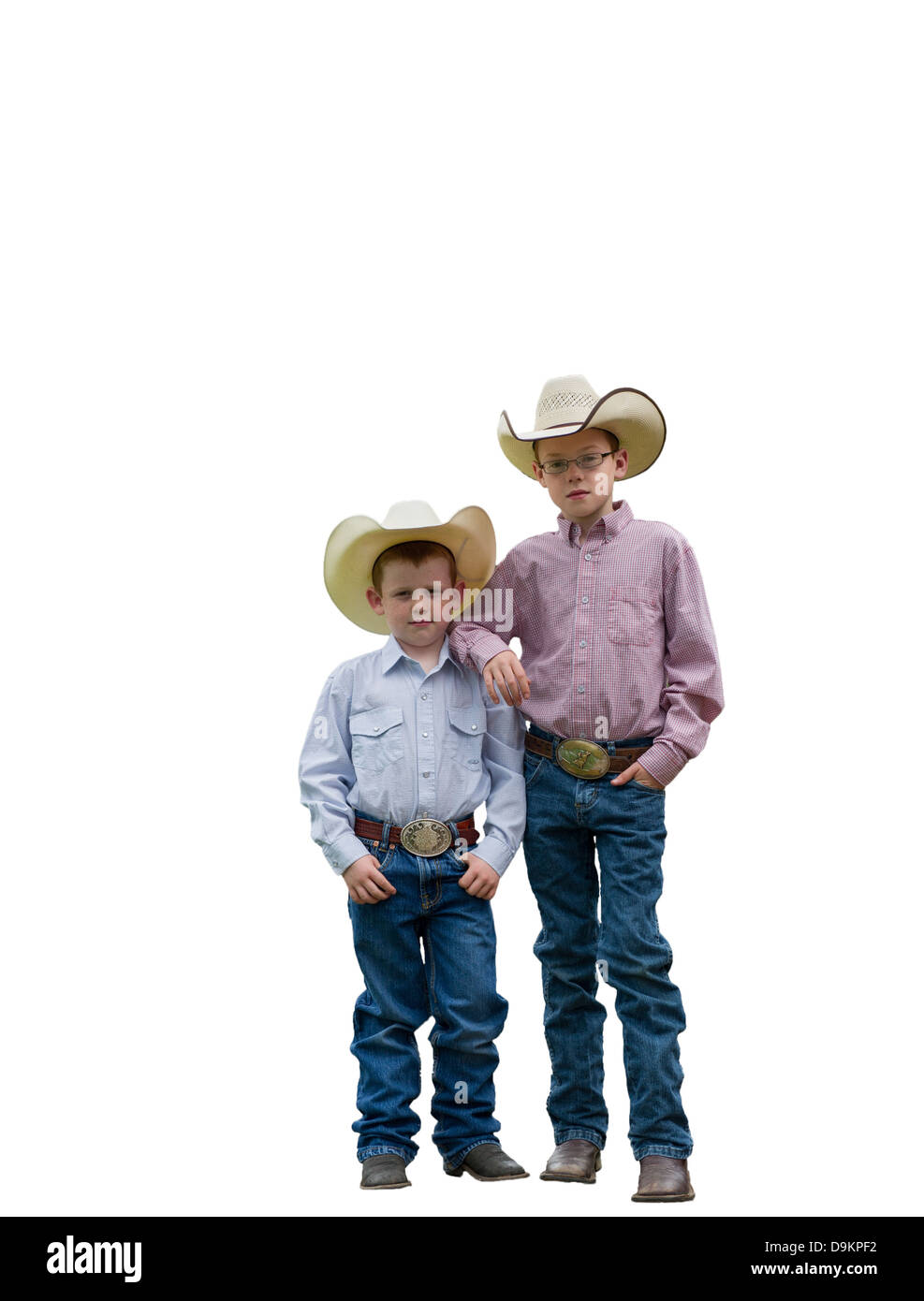 Dos jóvenes vaqueros en un backgorund blanco mirando a la cámara. Uno tiene sus brazos sobre los hombros de otros. Foto de stock