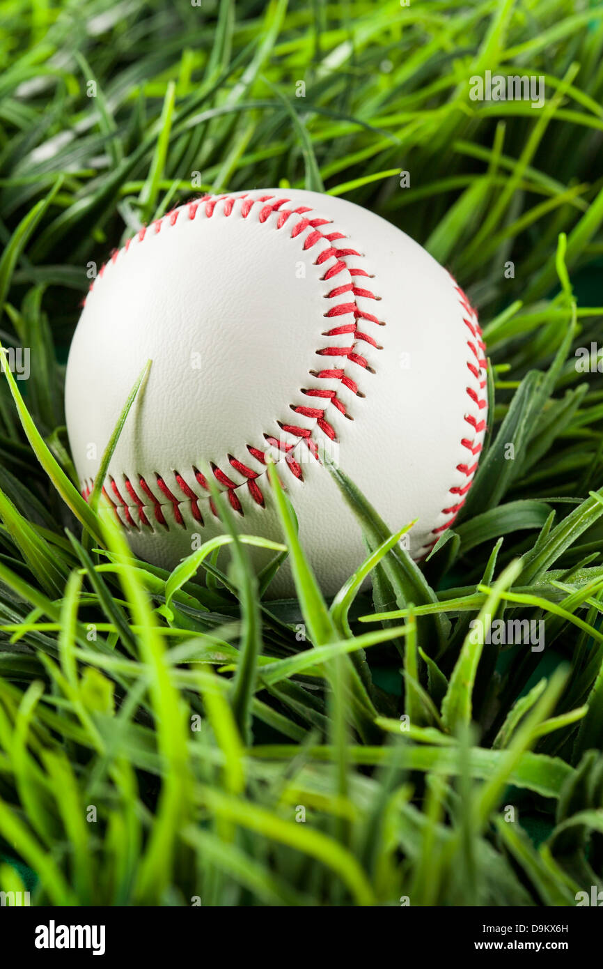 Nuevo blanco de béisbol en el pasto verde Foto de stock
