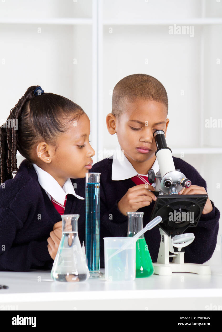 Niños de escuela primaria en clase de ciencias utilizando un microscopio  Fotografía de stock - Alamy