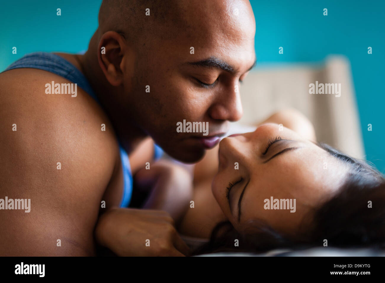 Adulto medio pareja besándose en la cama Foto de stock