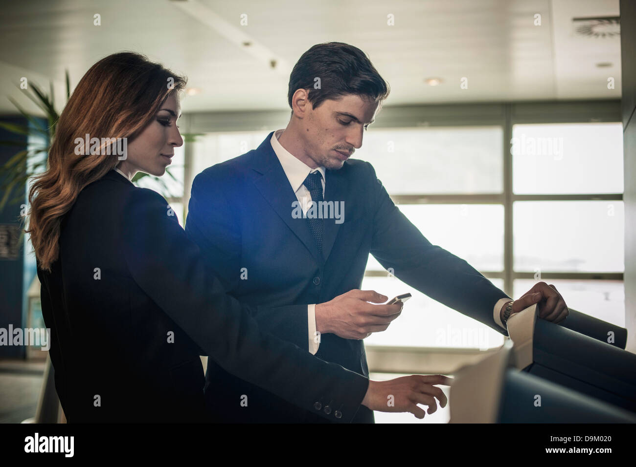 Los empresarios en el área de check-in del aeropuerto Foto de stock