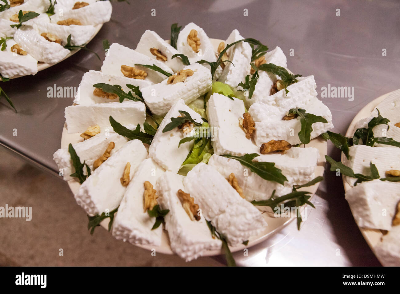 Tarta de queso de cabra con nueces y hojas de rúcula. Foto de stock