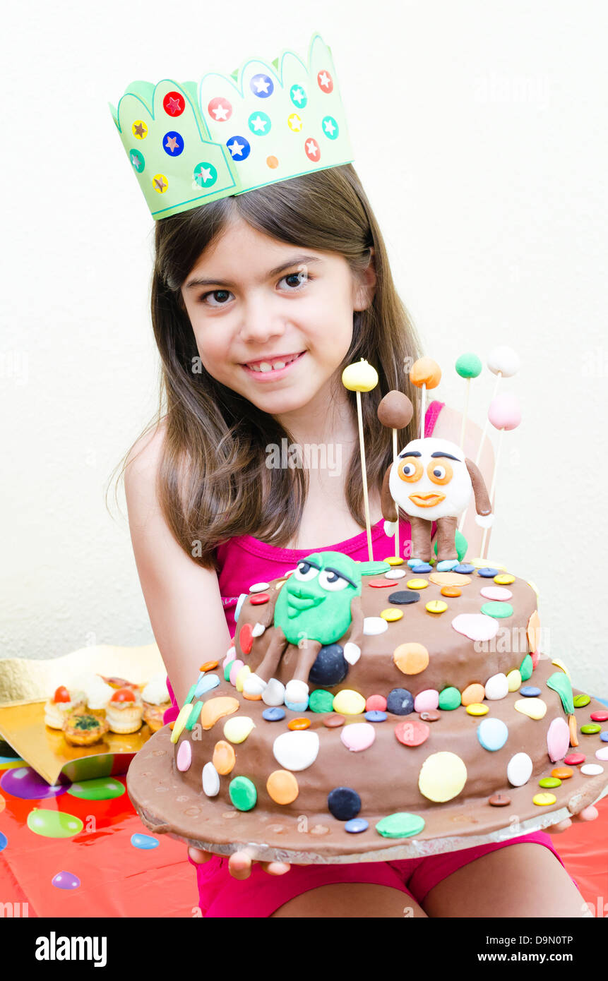 Linda Chica sujetando una torta en su cumpleaños Foto de stock