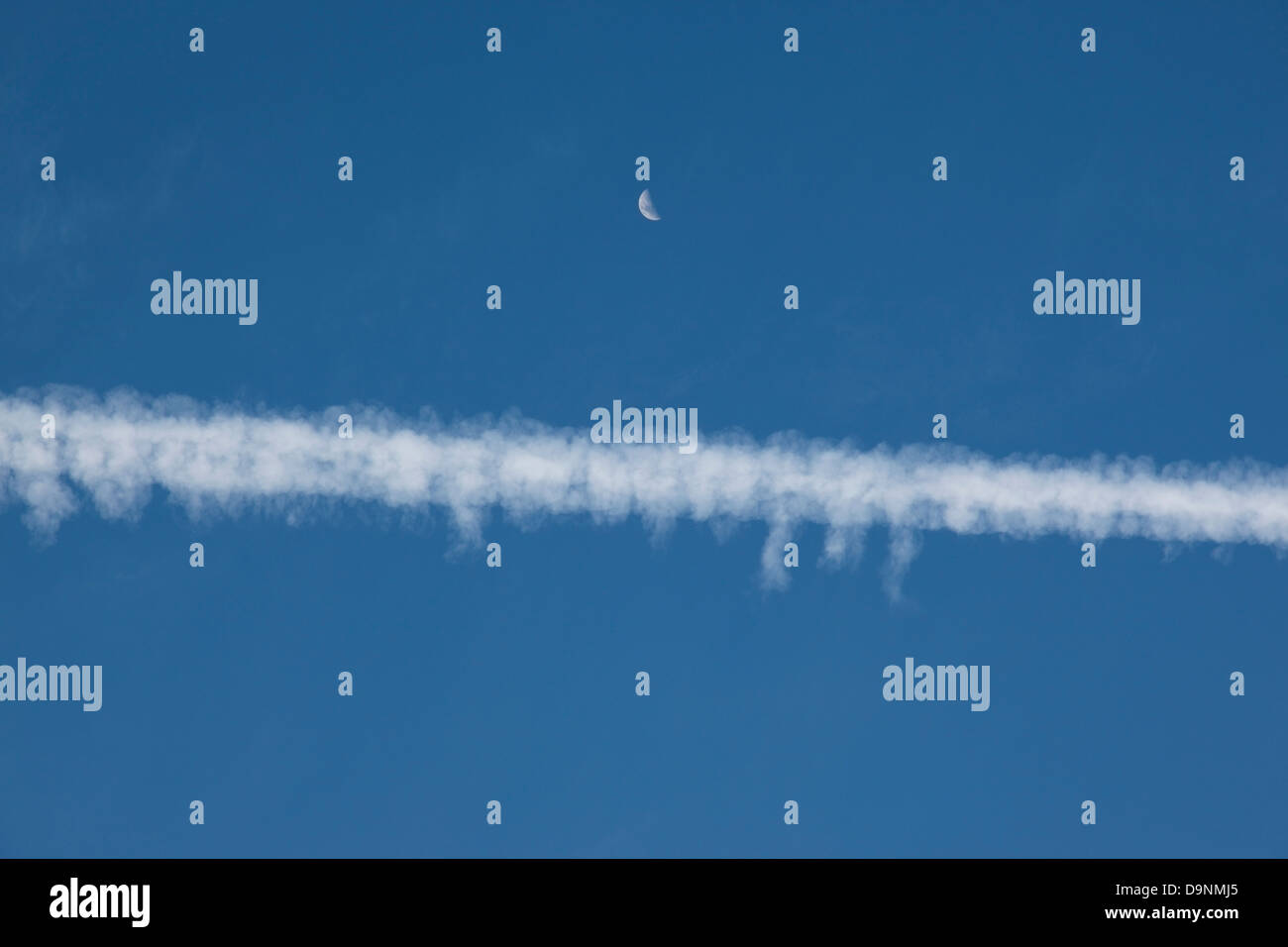 Las estelas de condensación de aviones y Luna diurna, Australia Foto de stock