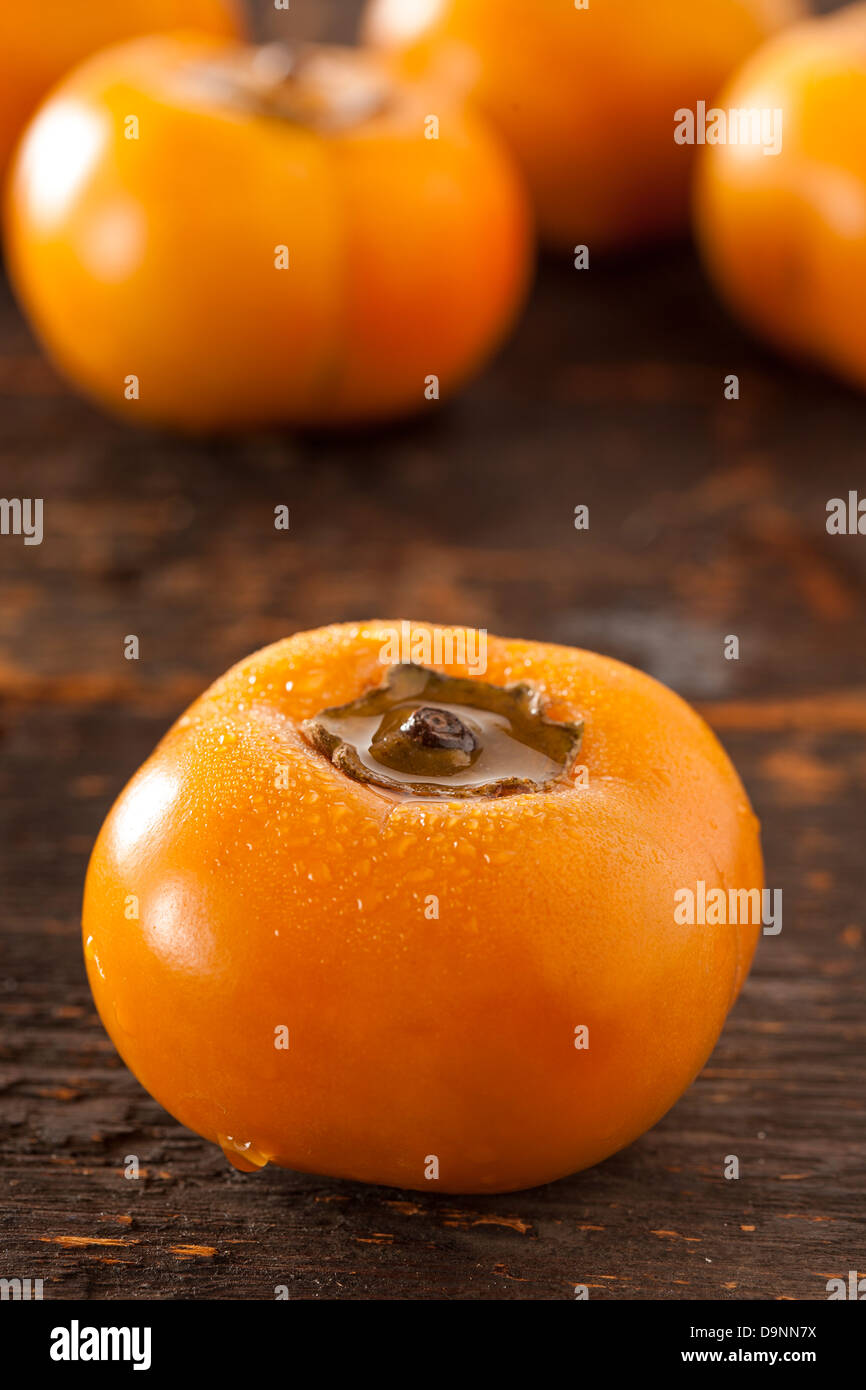 Fruto de caqui naranja orgánico contra un fondo Foto de stock