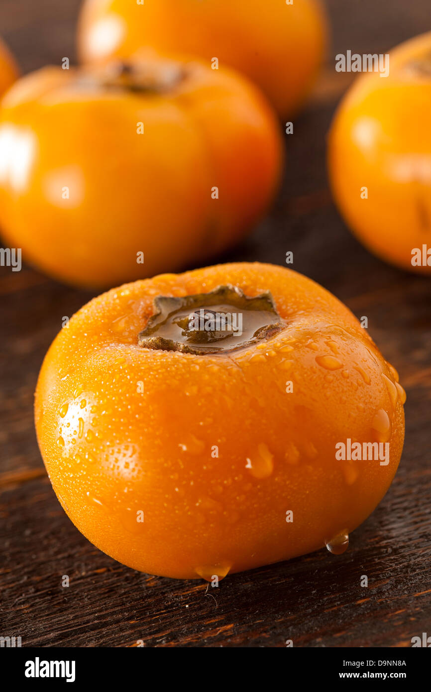 Fruto de caqui naranja orgánico contra un fondo Foto de stock